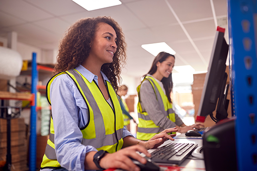 women in warehouse working on computers